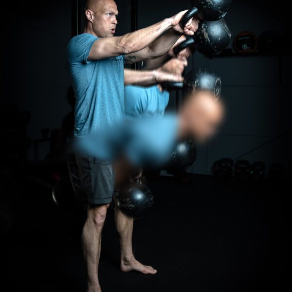 Trainer Ronald voert een kettlebell swing uit.