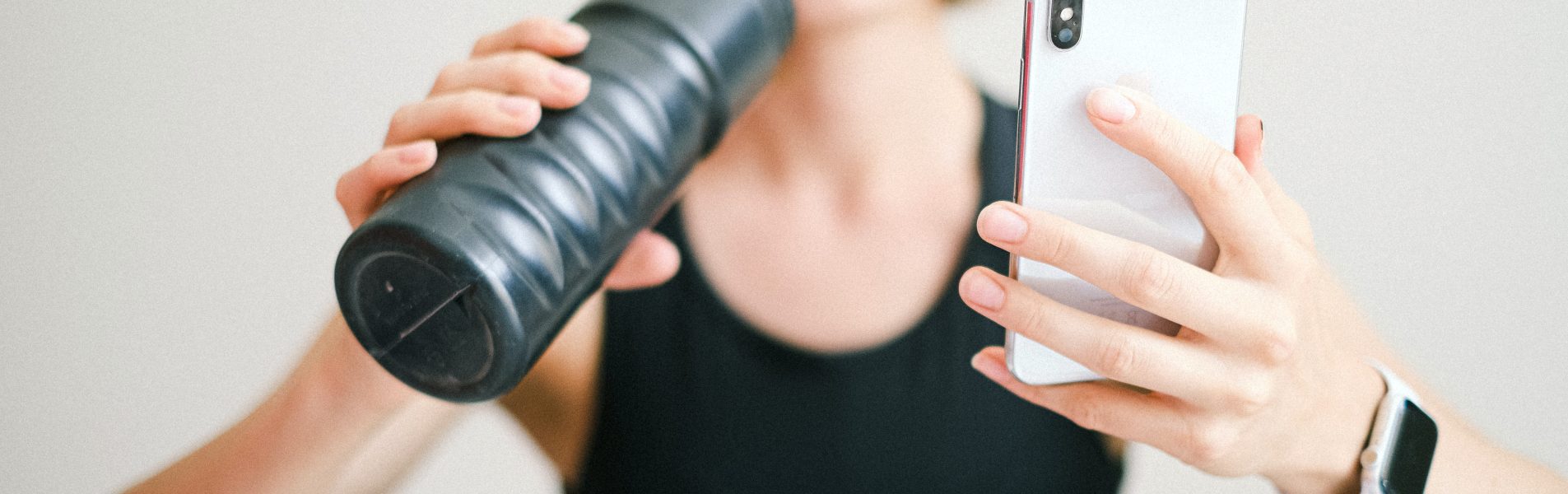 ondernemer die sport en kijkt op mobiel en daarbij gezondheid en ondernemen combineert
