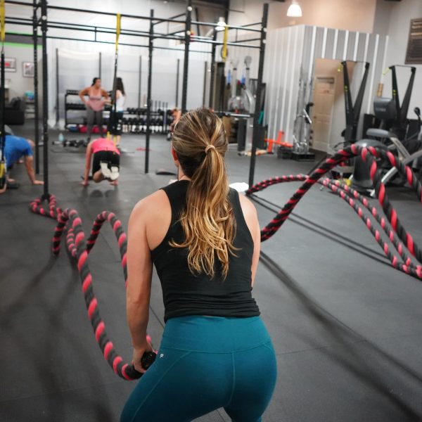 Vrouw die haar spiergroepen aan het trainen is door middel van een touw oefening