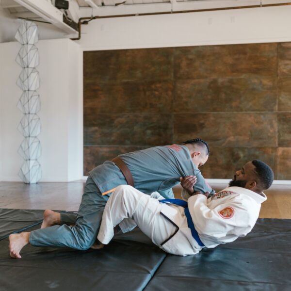 twee mannen liggen op de trainingsmat en beoefenen brazilian jiu jitsu